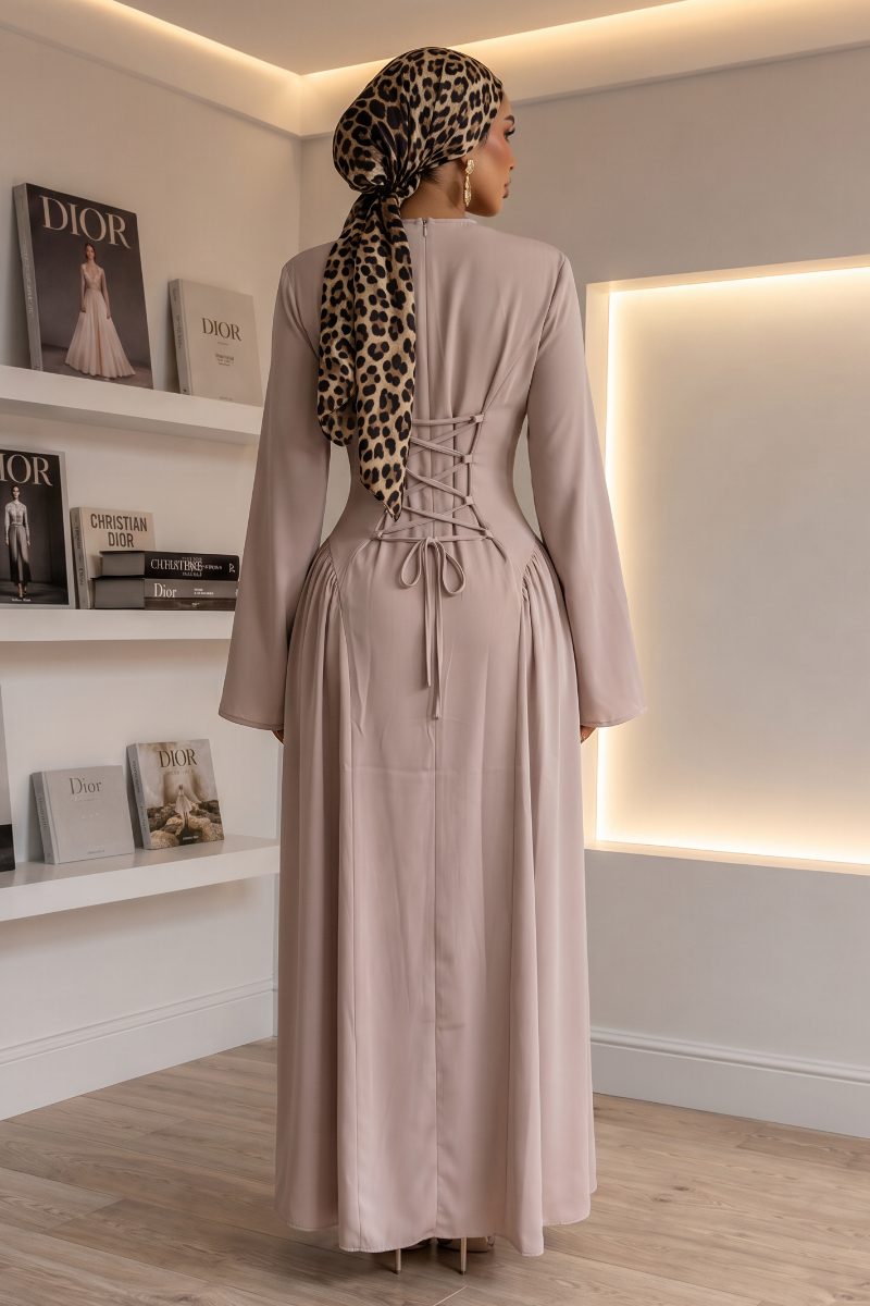 A woman wearing a long-sleeved taro maxi abaya with a lace-up back, paired with a leopard-print headscarf